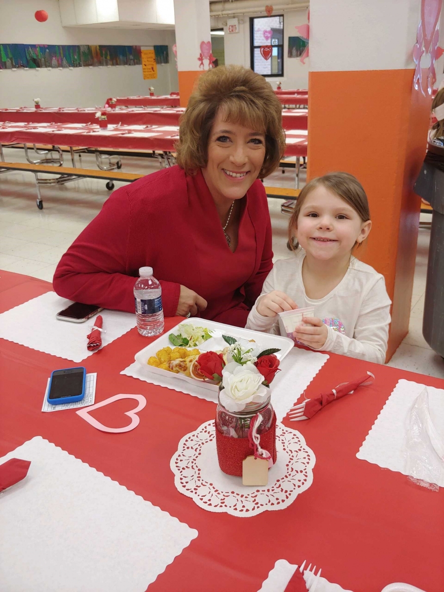 woman and a girl smiling at a table